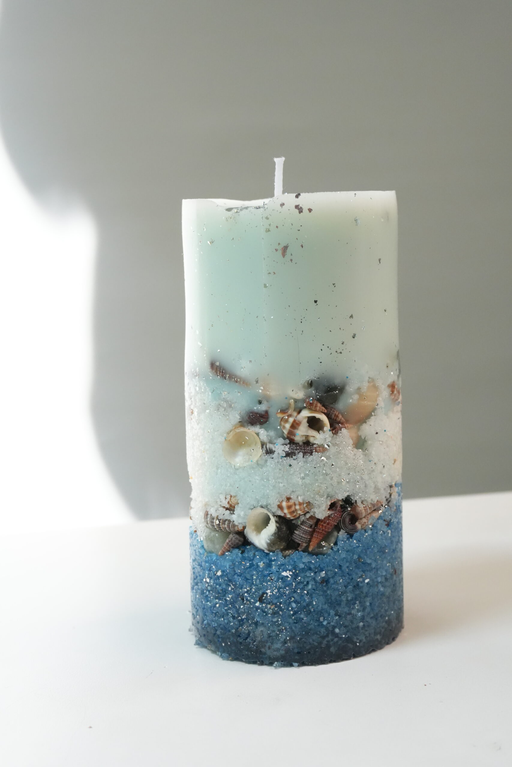 Seashore Pillar Seashell Candle Tall sea-mist pillar candle with silver leaf, seashells and blue sand base by dEeArtify Studio