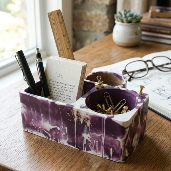 Large plum and white marbled jesmonite pen holder with pens, notepad and gold clips on a wooden desk